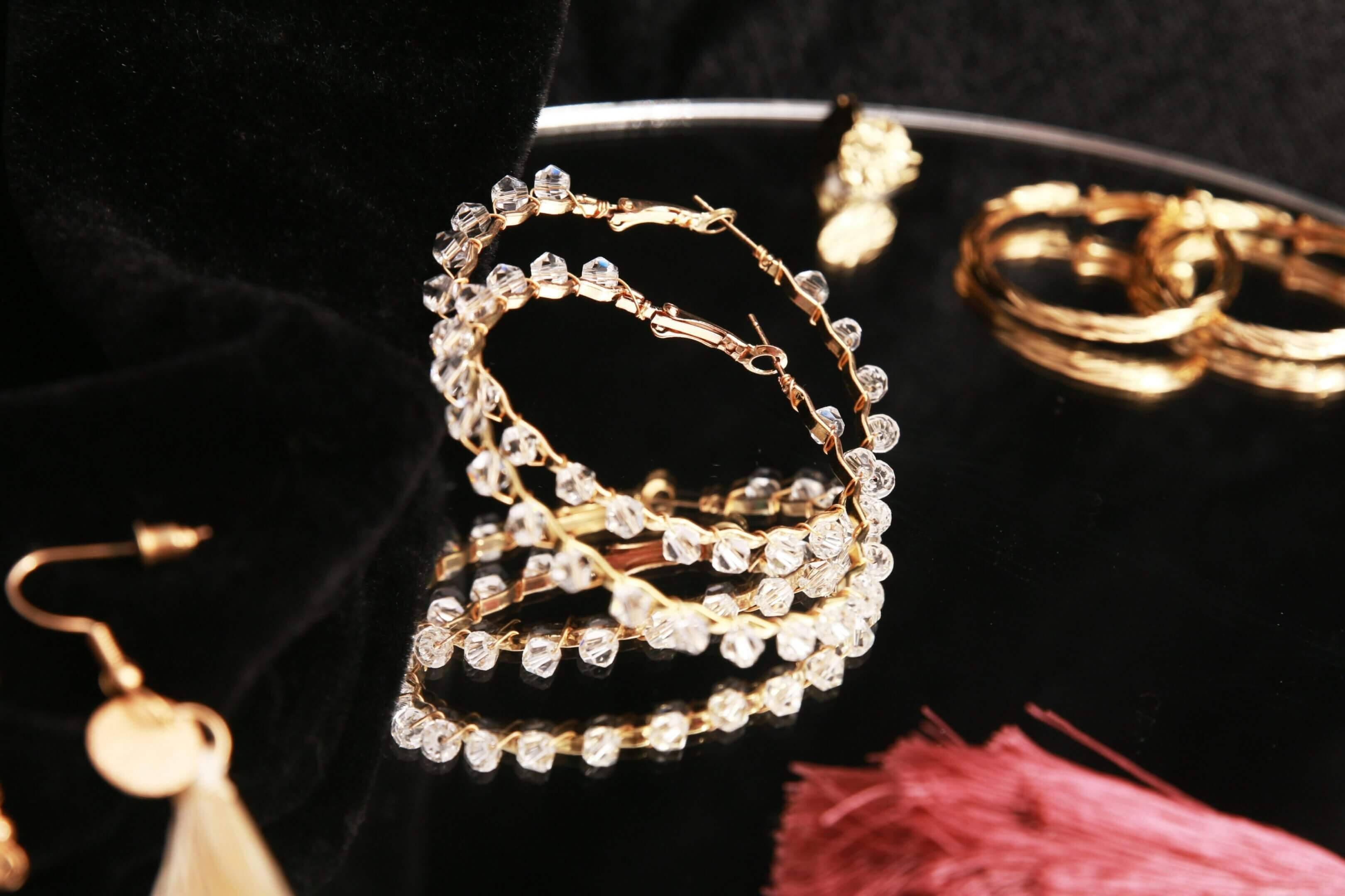 Elegant gold hoop earrings adorned with sparkling clear stones.