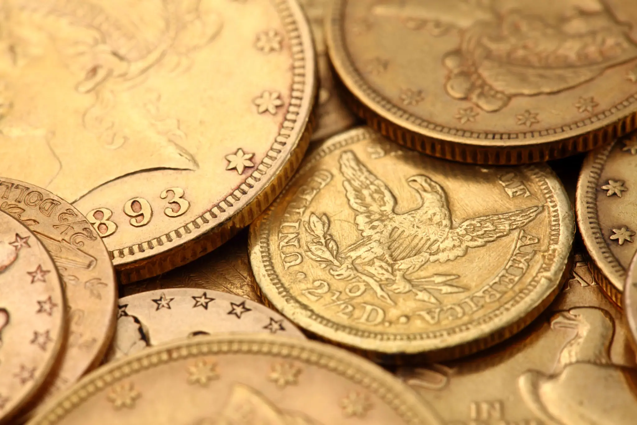 Close-up of old gold coins with intricate designs.